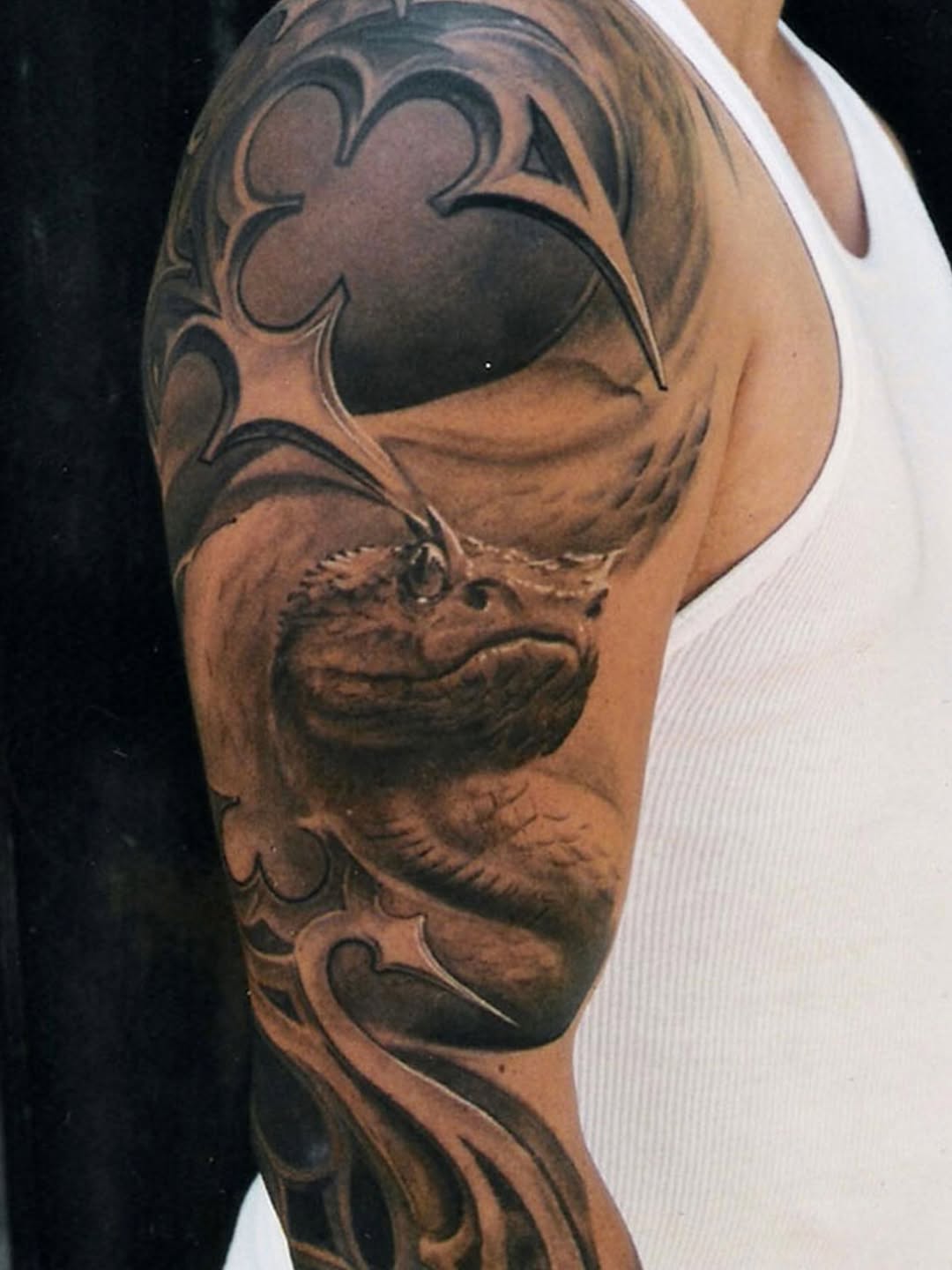 Black-and-grey demon mask sleeve tattoo