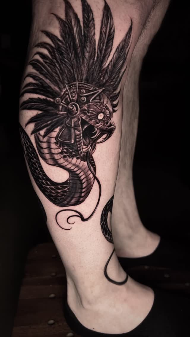 Black-and-grey demon skull with feathers, calf