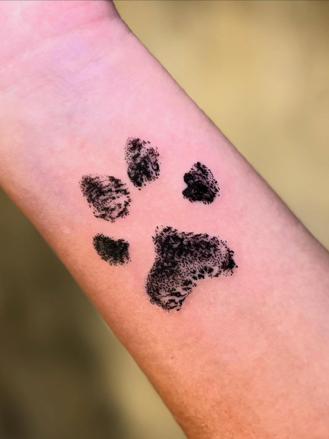 Dog paw print tattoo, arm