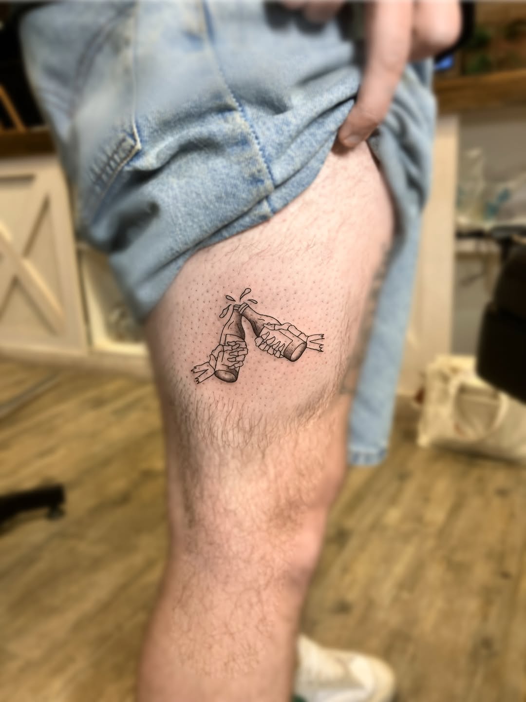 Fine-line skeleton toast thigh tattoo